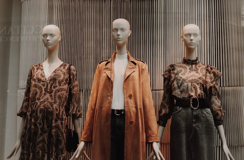 Three mannequins dressed in brown and black clothing