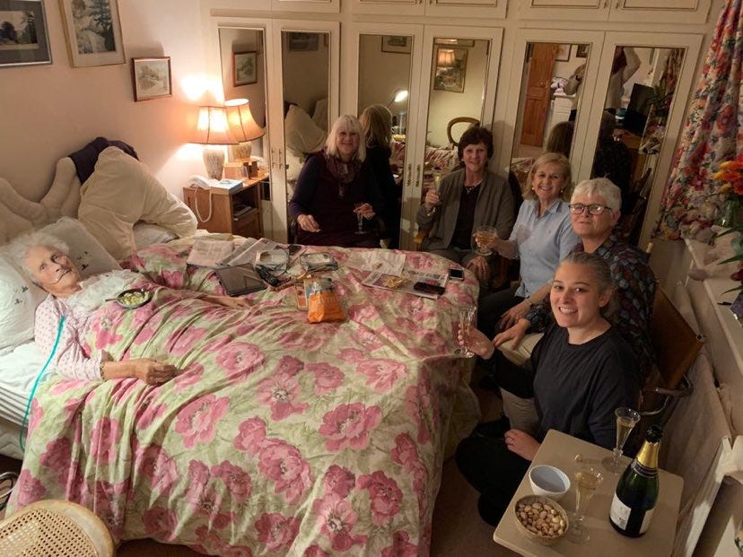 Granny in bed surrounded by her four daughters and me drinking champagne