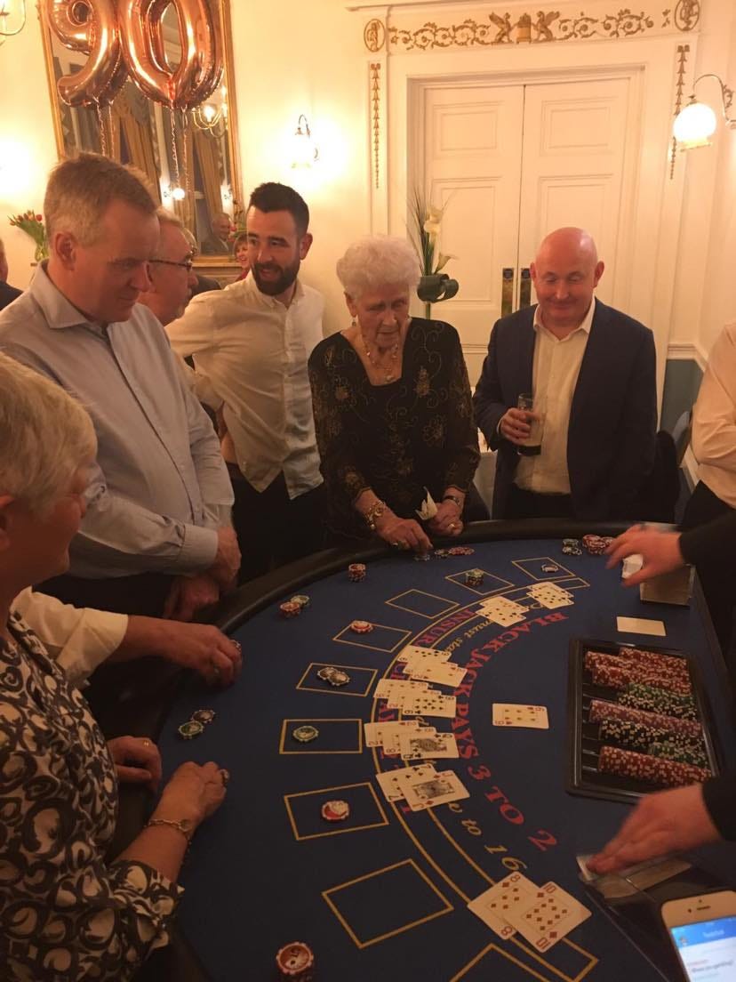 Granny at a poker table surrounded by relavtives