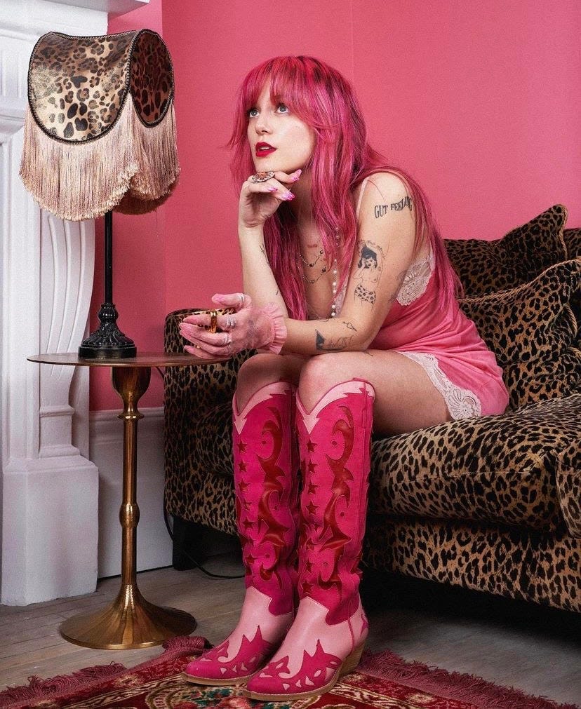 Florence given in pink outfit sitting on leopard print sofa