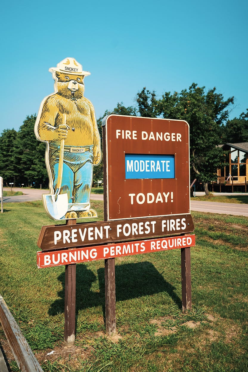 A Smokey Bear sign in front of a park