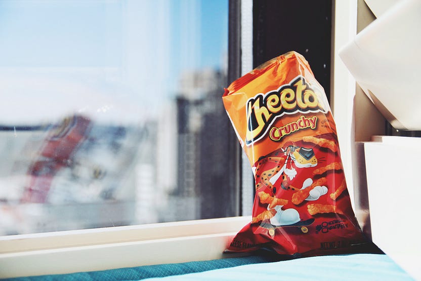 A bag of Cheetos in front of a window