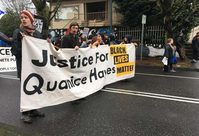 Protest marchers with a large horizontal side that reads “Justice for Quanice Hayes Black Lives Matter”