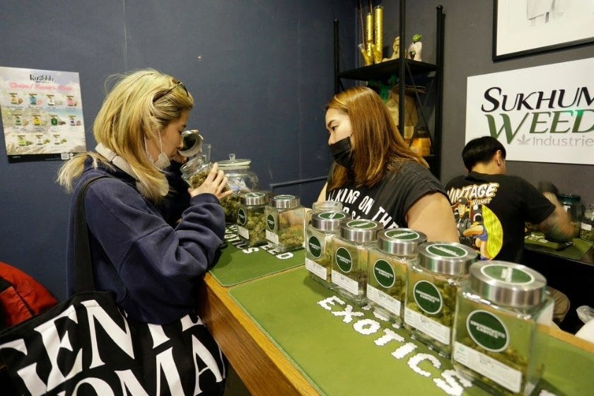 A budtender at a cannabis dispensary helping a woman smell cannabis strains at a dispensary.
