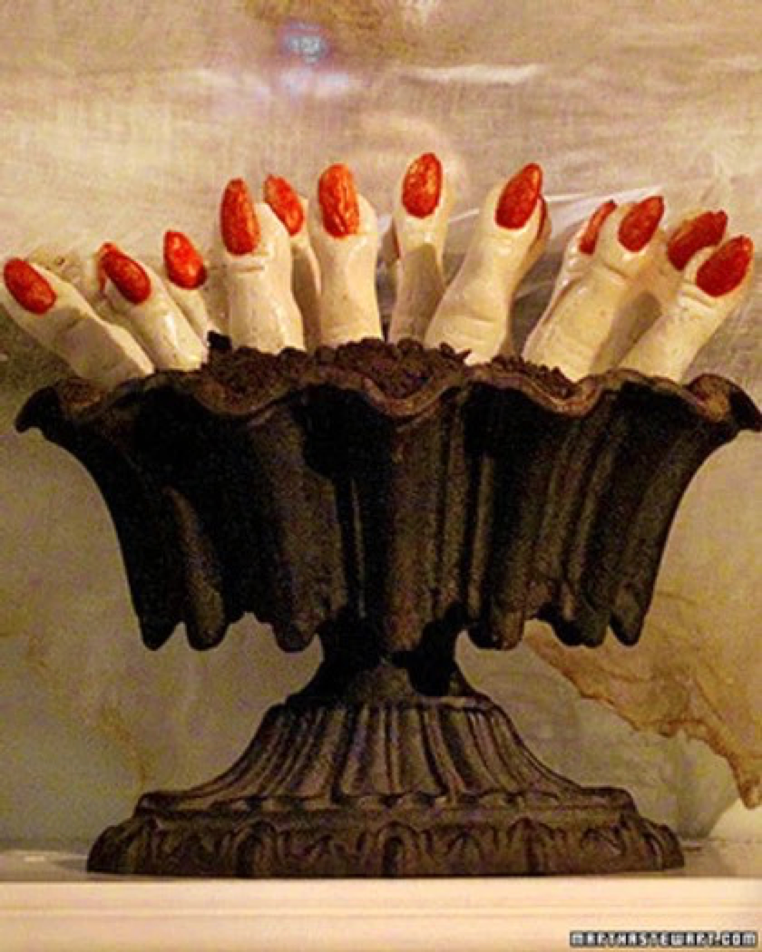 Image of cookies shaped like fingers with red fingernails, in a chocolate cake bowl.