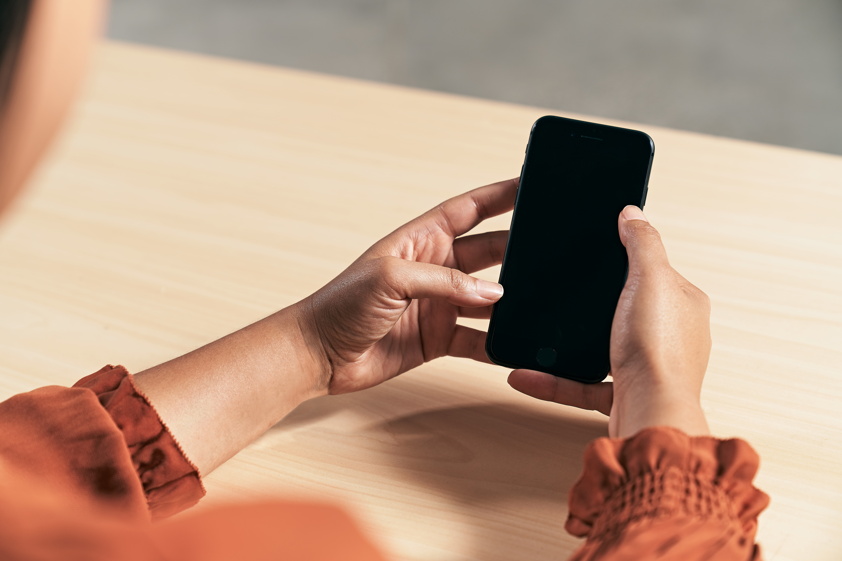 A woman’s hands holding an iPhone