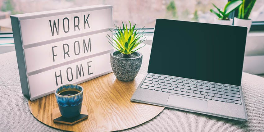 Working from home sign, with laptop and tea on a table