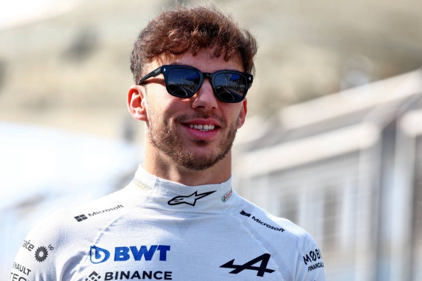 Pierre Gasly strolling along with a smile and wearing sunglasses during pre-season testing with Alpine.