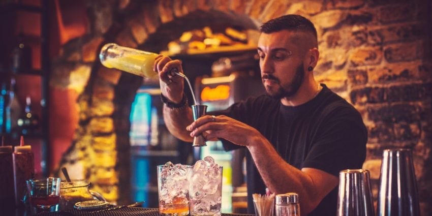 A bartender prepares a mixed drink.