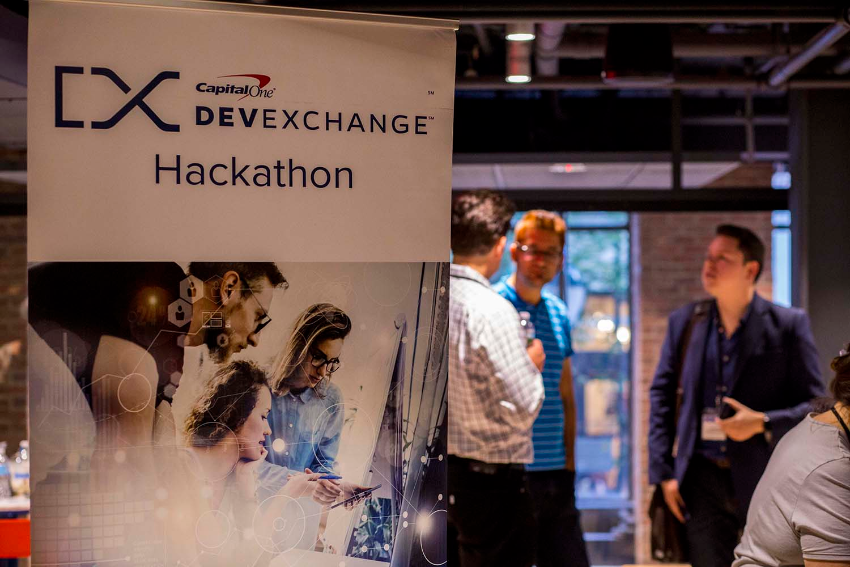 DevExchange Hackathon banner with several people having a discussion in the background.