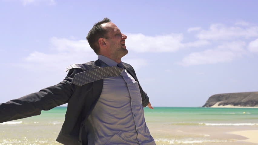 Happy businessman at the beach