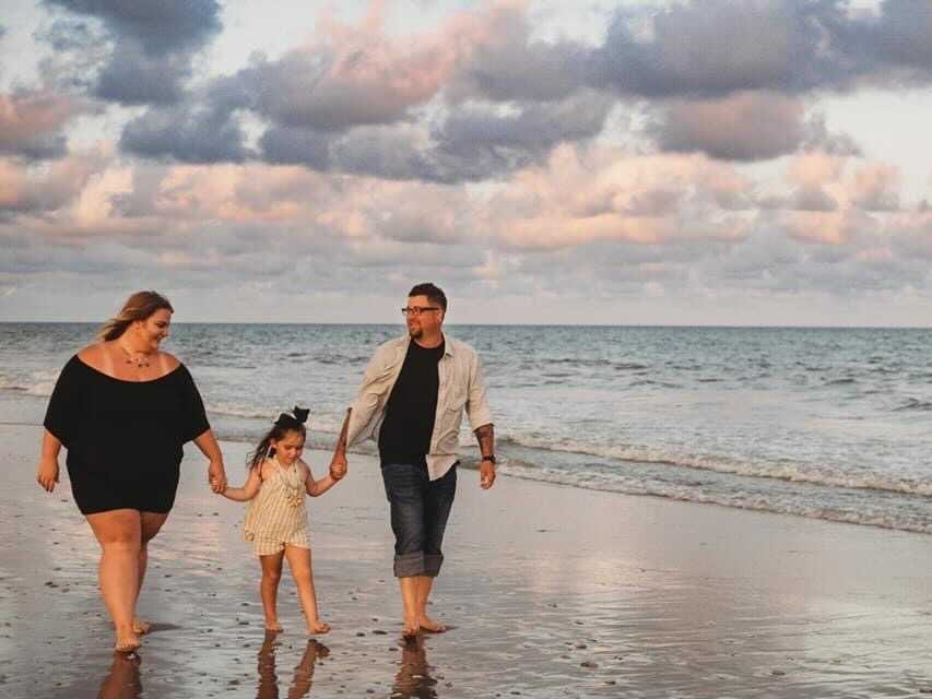 Individuals walking on the beach.