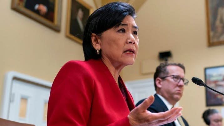 Representative Judy Chu in red suit speaking in a Congressional meeting