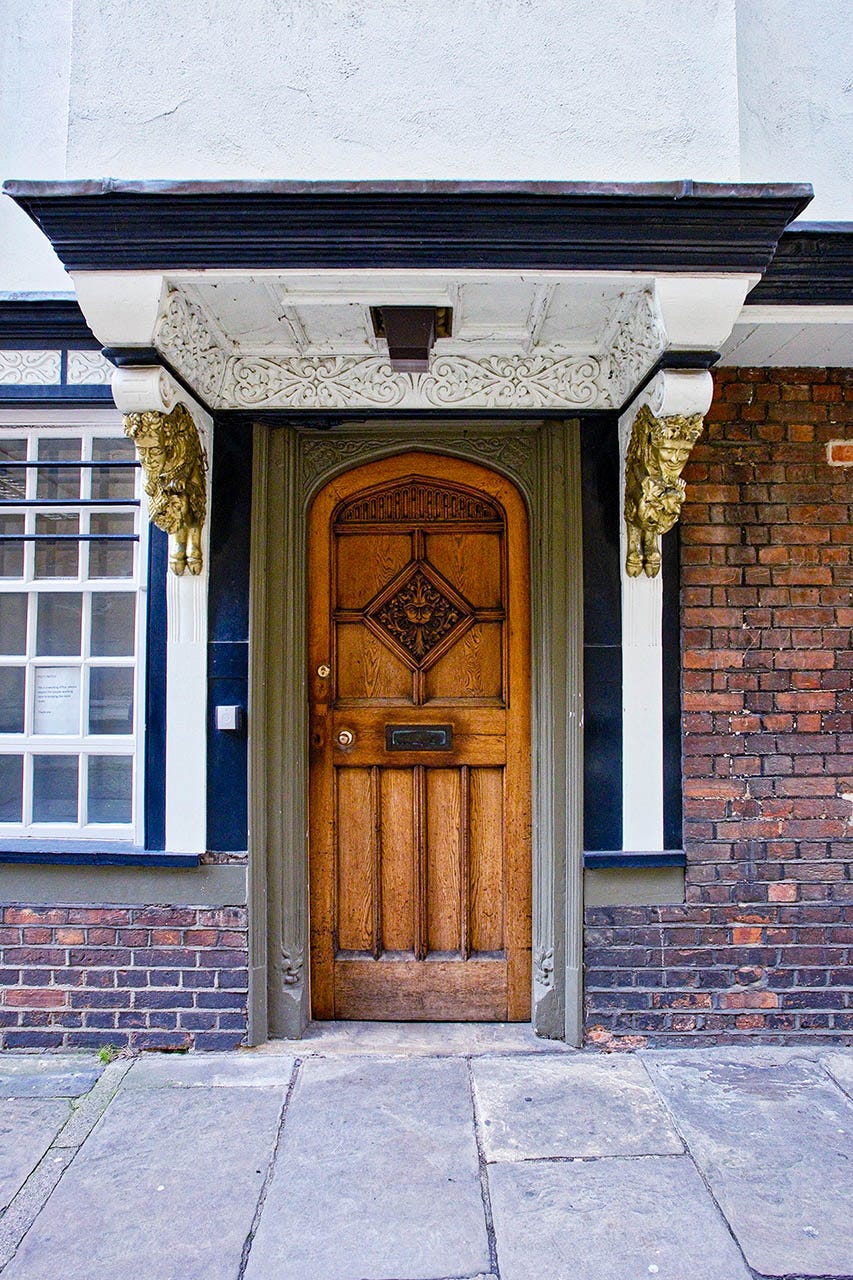 a unique wooden door with an ornate doorway bookended by intricate deatails