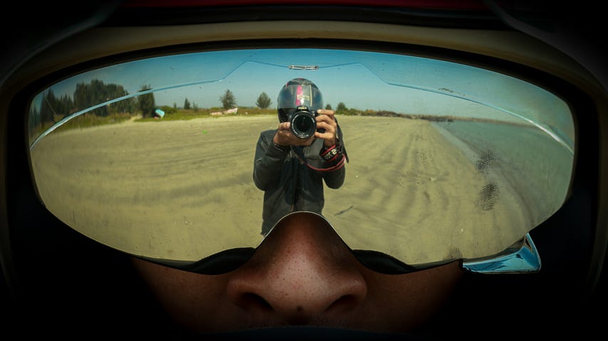 photo of a reflection of a person taking a picture in a set of mirrored goggles