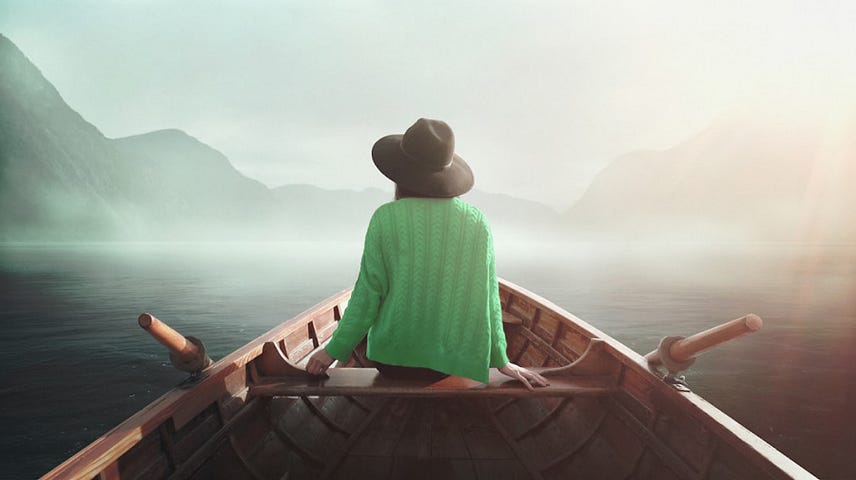 Jayden Yoon ZK took this photo of a woman wearing a floppy hat sitting in a rowboat adrift on a fog-covered body of water.