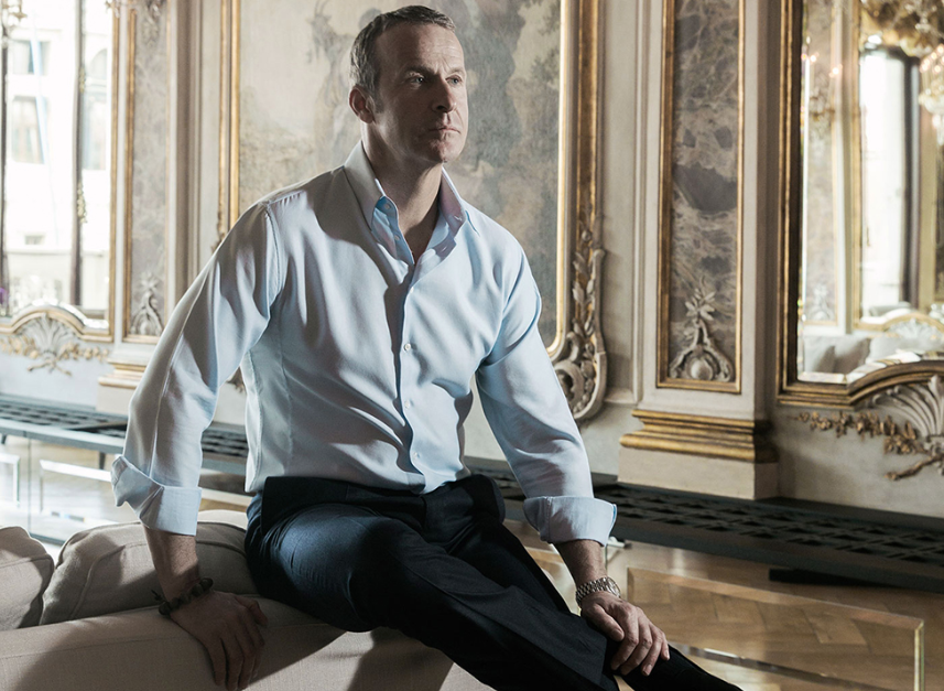 Vladislav Doronin in a suit seated on a couch in a royal luxury environment.