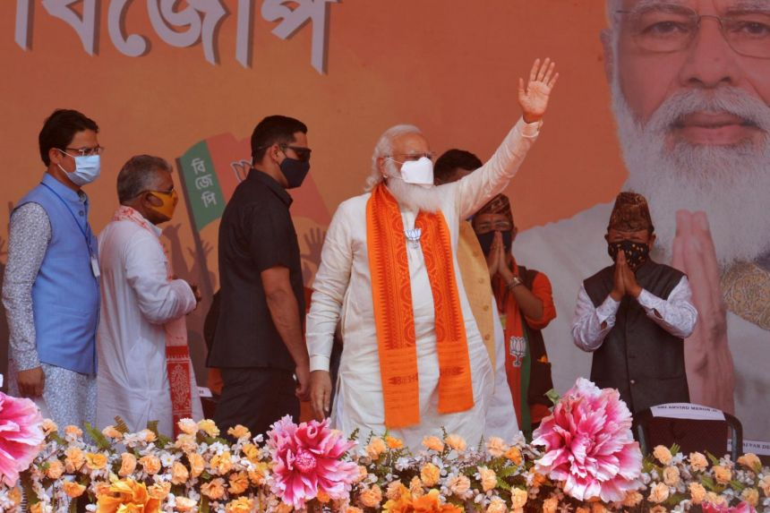 PM Narendra Modi (centre) waves to supporters in a rally meeting during at Kawakhali on the outskirts of Siliguri, on April 10, 2021.PHOTO: AFP
