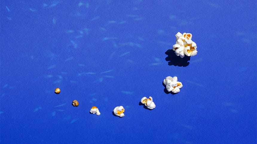 A series of 7 pieces of popcorn, arranged from the smallest unpopped kernel to the largest, fully popped kernel.