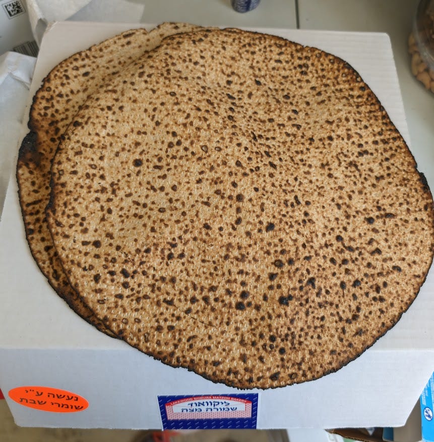 Two handmade shmurah matzot on top of the box they came in