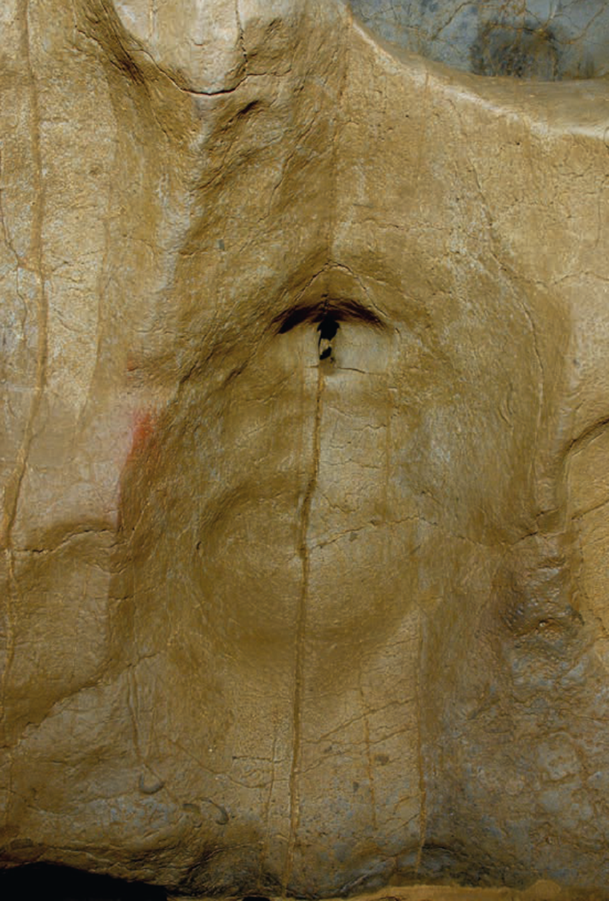 Hollow in cave wall with a slot-like hole in it. It’s not exactly like a vulva, but not exactly unlike one, either