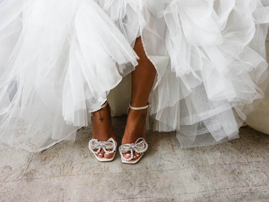 The feet of a young, African-American bride beneath a flowing dress