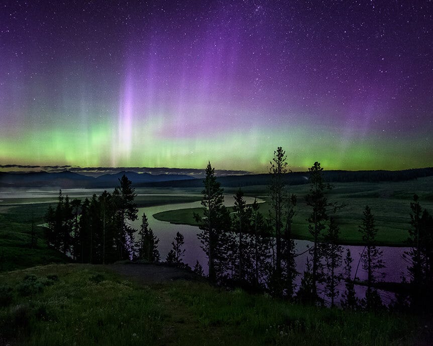 Northern lights over national park landscape, with winding river and trees