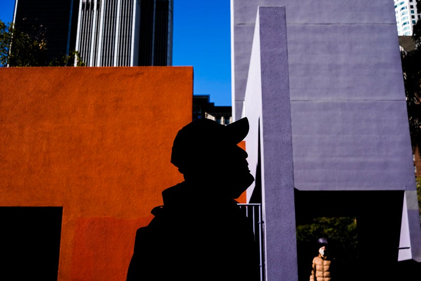 Silhouette of a man in front of bright orange and purple buildings