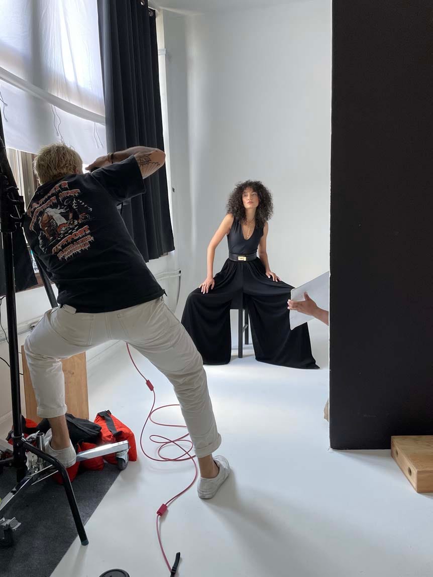 Man photographing fashion model in studio