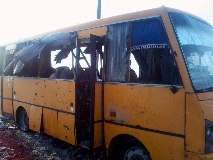 A yellow bus riddled with bullet holes