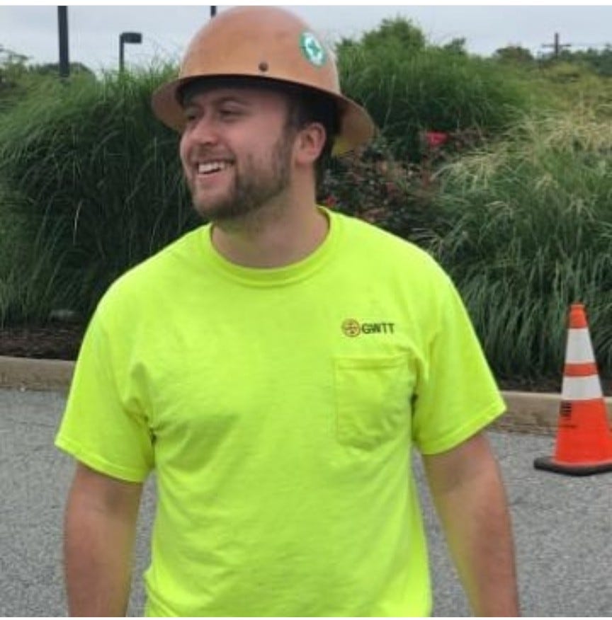 Ben smiles with a hardhat and neon yellow t-shirt.