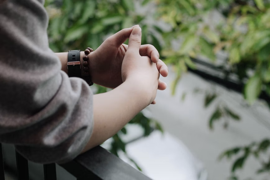 close up of persons hands as they overlook a balcony