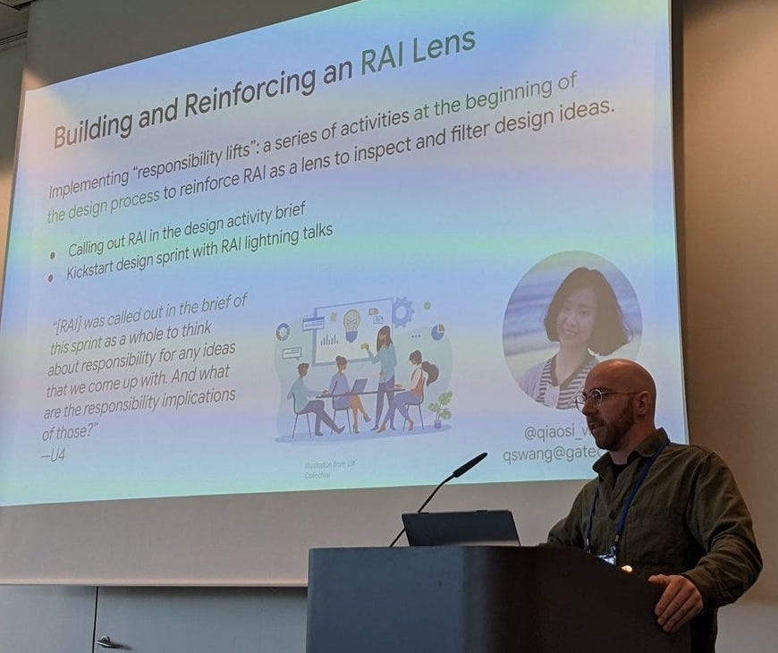 Michael Madaio, shown wearing glasses and an oxford shirt, at a podium at ACM CHI 2023, presenting Qiaosi (Chelsea) Wang et al.’s paper on designing responsible AI. The slide shows “Building and Reinforcing an RAI lens” as its title.