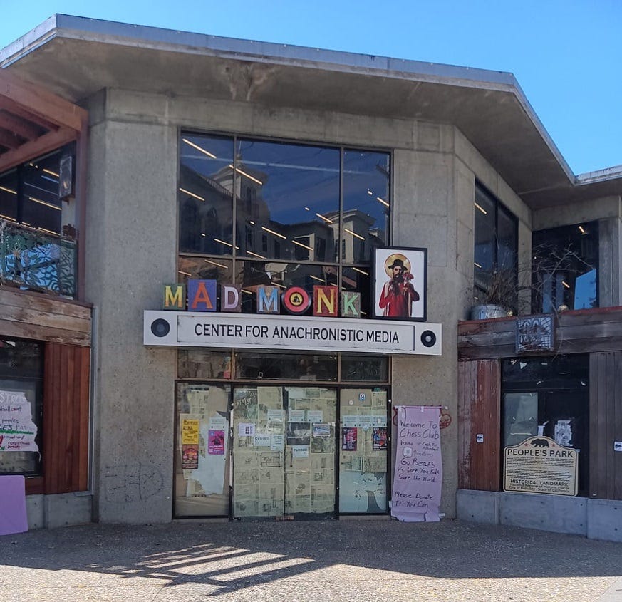 The former Cody bookstore building with its gray concrete walls and large windows in Berkeley, CA on a sunny day.