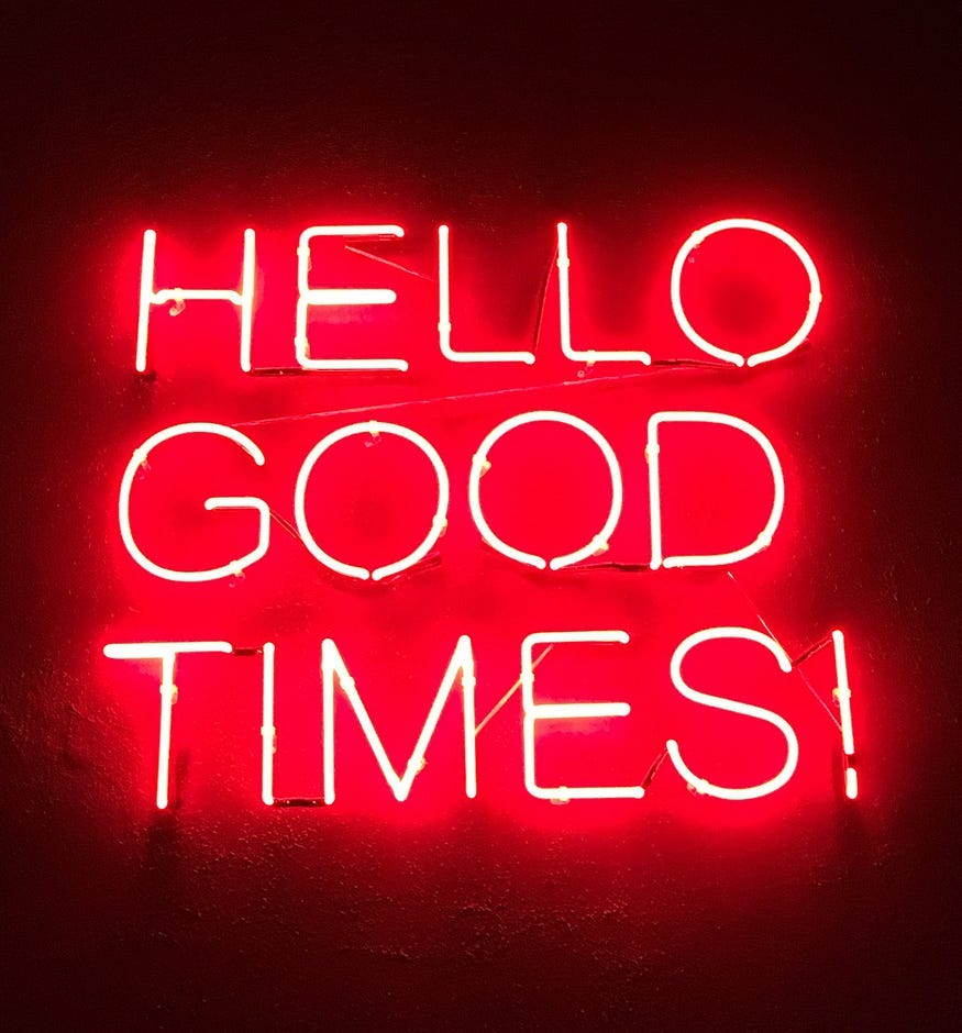 A red neon board with text “Hello good times!”