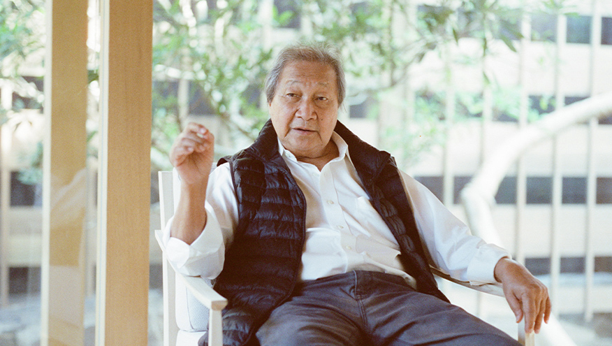 Adrian Zecha, founder of AMAN resorts seated on a chair in an office setting.