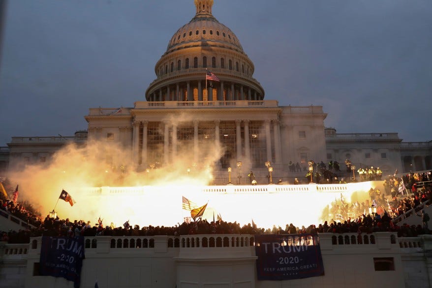 An explosion caused by a police munition is seen while supporters of U.S. President Donald Trump gather in front of the U.S. Capitol Building.