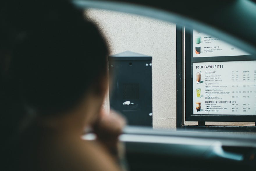 people at a drive through ordering drinks. reach out to as many people as you can to grow your brand.