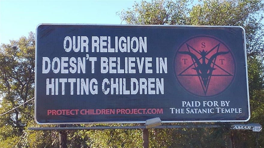 “Our religion doesn’t believe in hitting children” billboard paid for by The Satanic Temple