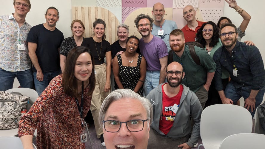 A group photo of 16 people standing.