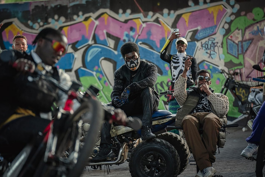 A bike gang lounge in front of graffiti wall