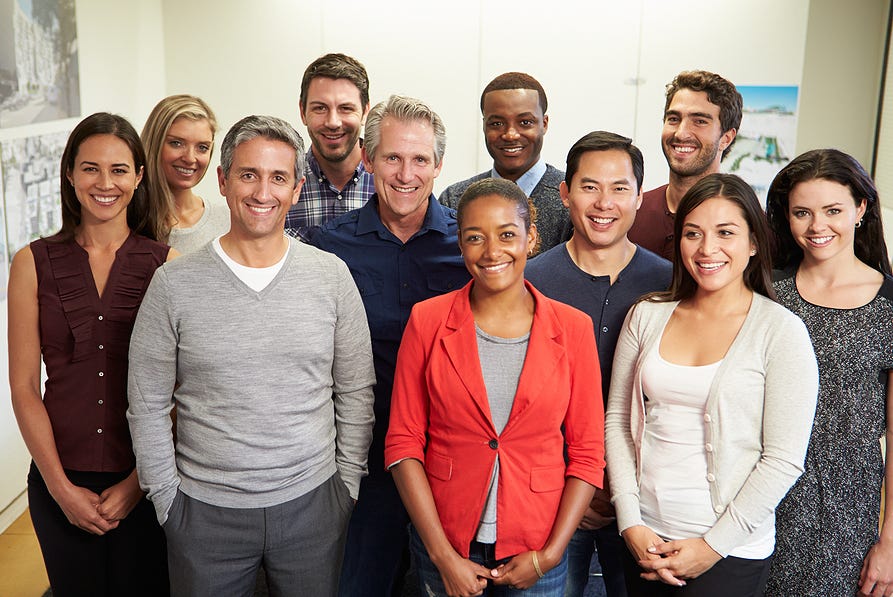 photo of the a smiling and diverse business team — includes a ranges of age, gender and race