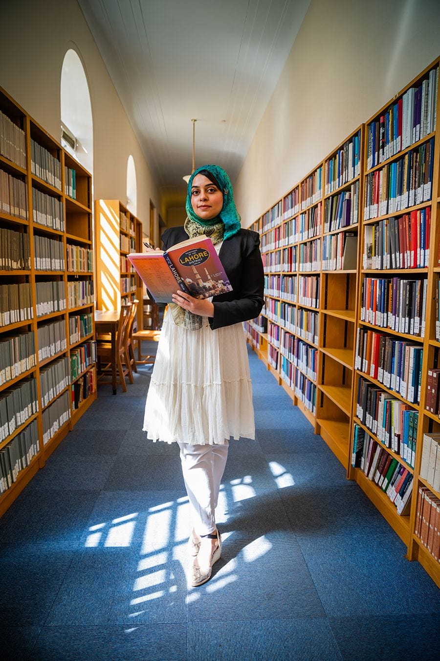 Rihab Khalid holding book in library