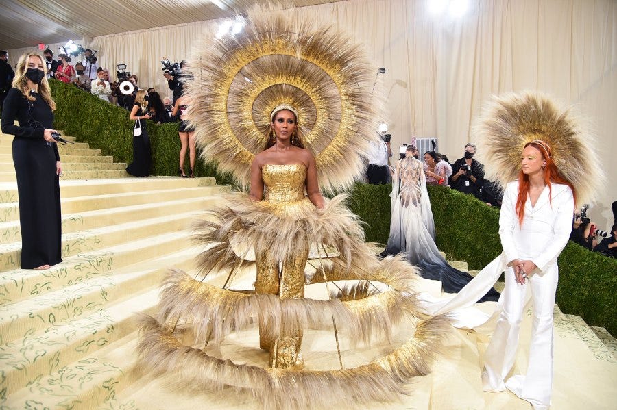 Iman, wearing a feathery gown, and Harris Reed on the steps of the Met.