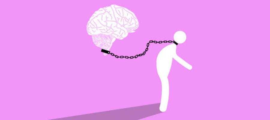 An image of a brain chaining a human body, which is a representation of the paradoxical nature of the classical definition of free will.