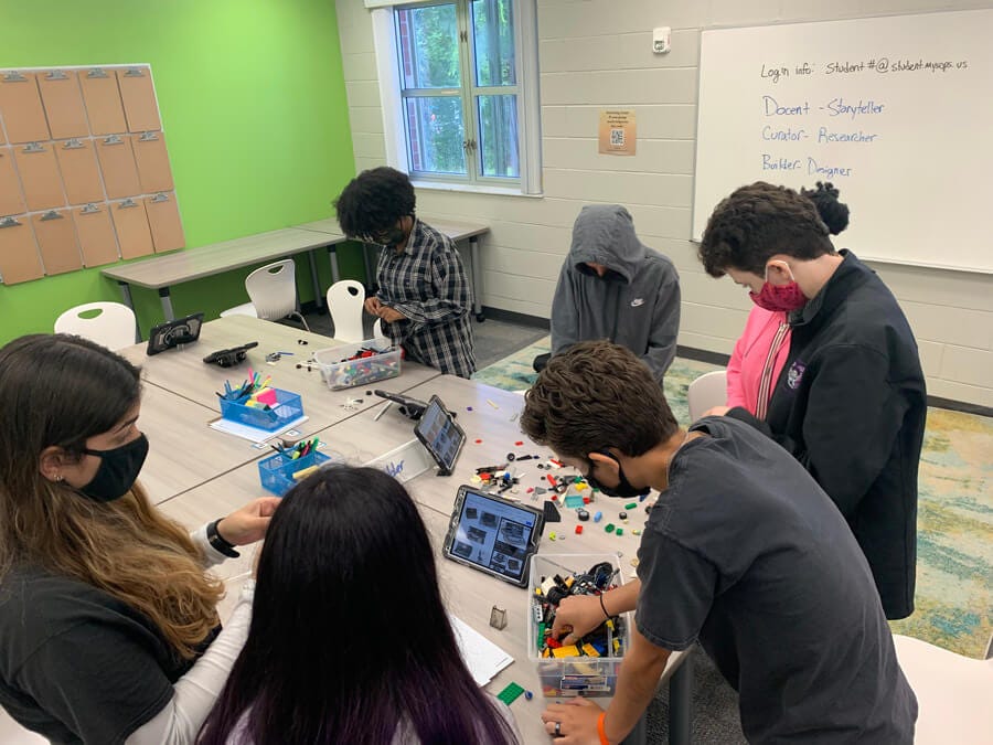 Close-up of several students using LEGOs to practice ideation and prototyping