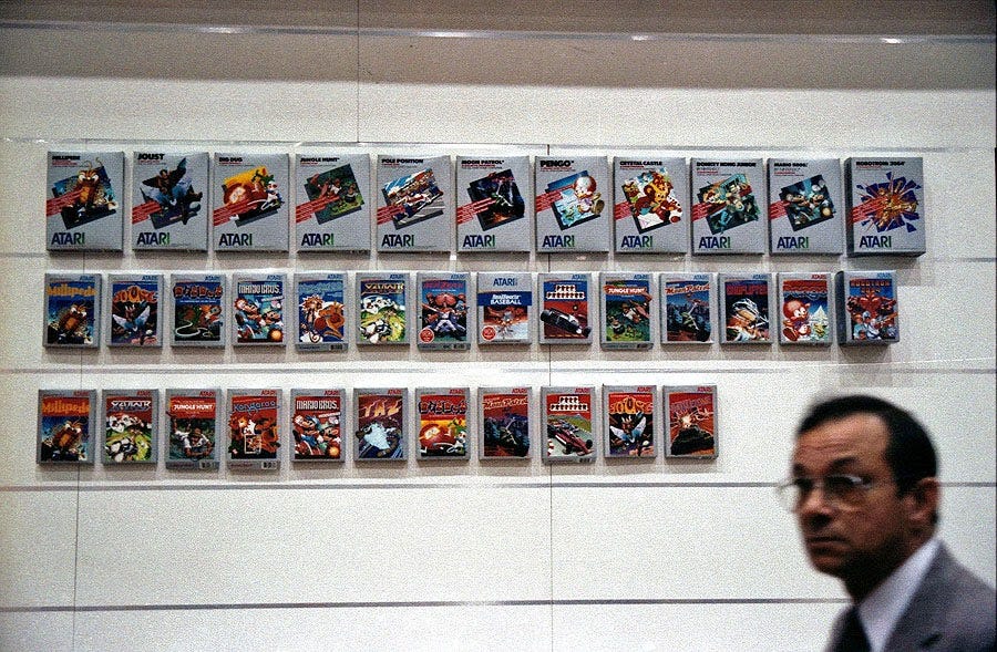 Atari 2600 game boxes displayed on a wall at a CES Expo.