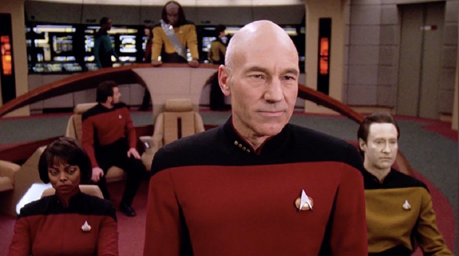 An image from Star Trek, showing Captain Piccard and others wearing “universal translators”.