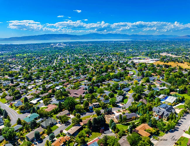 Vibrant neighborhood in Provo Utah showing a clear view of the sky with a variety of homes and mountains in the background. Image captured by Katerina Gasset of the Gasset Group Real Estate Team in Utah