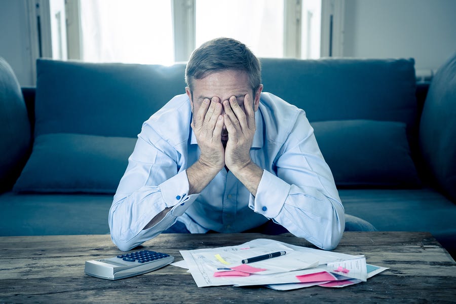 Stressed man in business clothes sitting at home